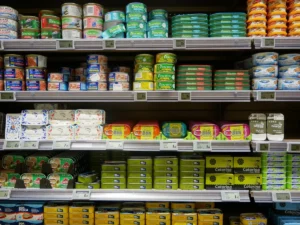 Supermercado con etiquetas de descuento en productos frescos y personal revisando inventarios.