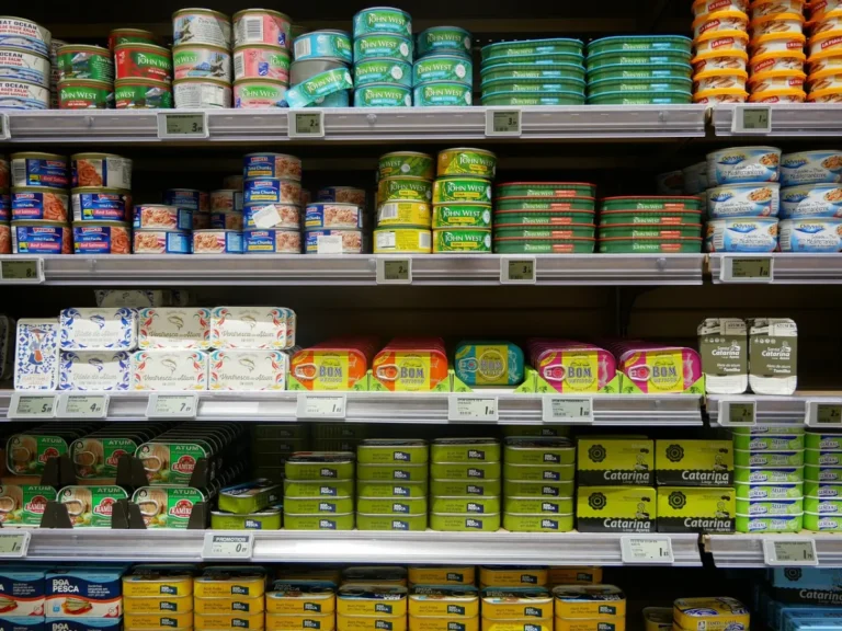 Supermercado con etiquetas de descuento en productos frescos y personal revisando inventarios.
